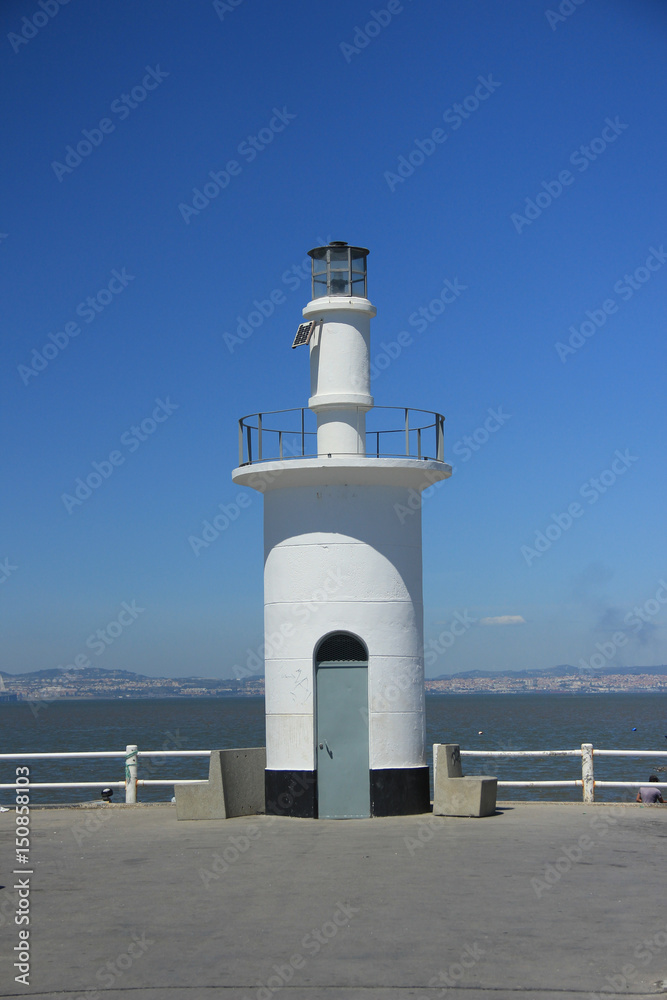 Lighthouse with a portugue tradicional boat in background. Alcochete, Portugal Lighthouse with a portugue tradicional boat in background. Alcochete, Portugal