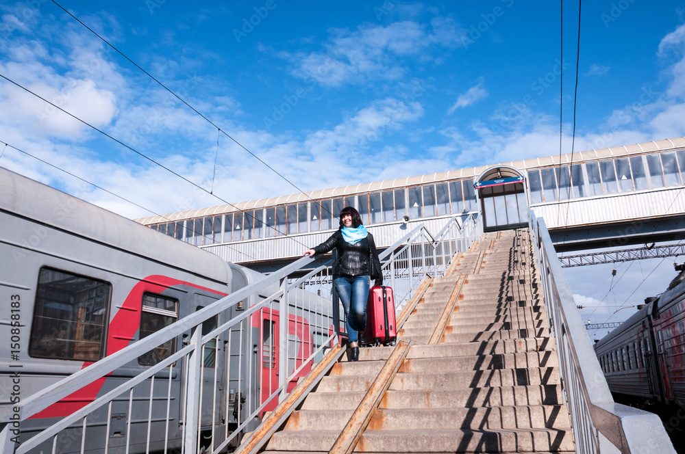 Girl with a suitcase near the train