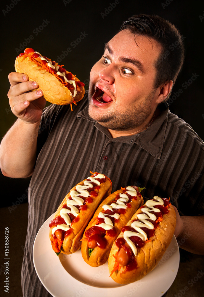 Foto de Diet failure of fat man eating fast food hot dog on plate ...