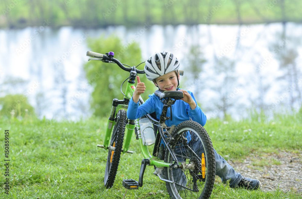 Fototapeta premium stolzer junger Biker mit seinem Rad in der Natur