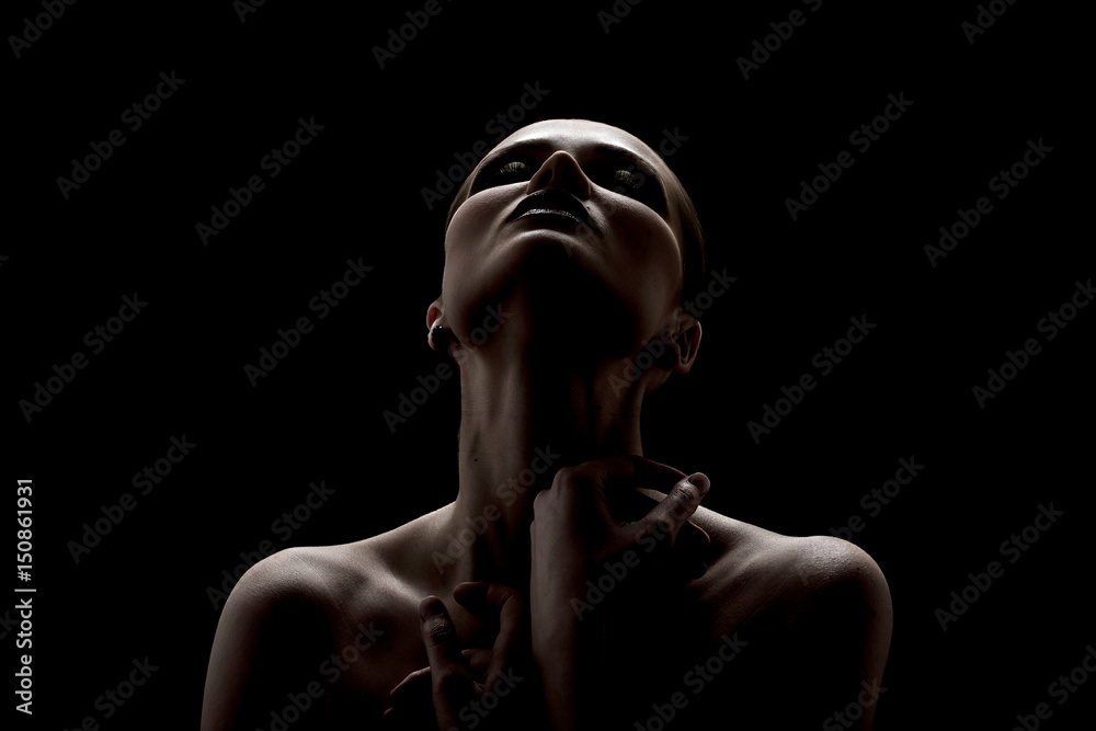 Black and white shot of woman posing sensually holding head up on black background
