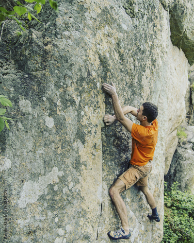 Fototapeta Naklejka Na Ścianę i Meble -  Rock climber reaching for his next hand hold Joshua Tree National Park.