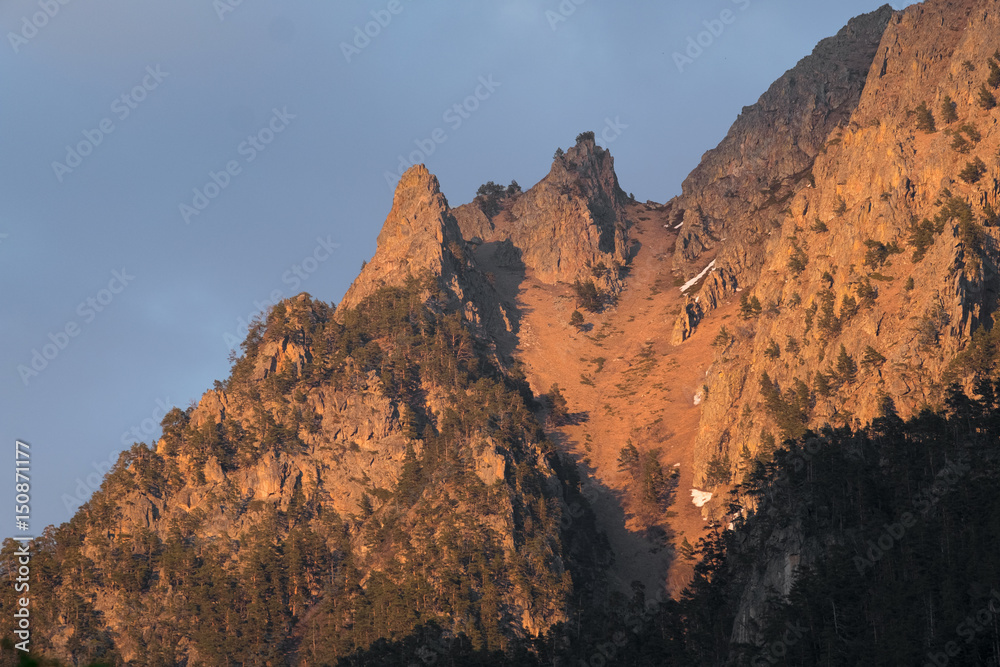 mountain peaks in summer at sunset or dawn, the light of the sun