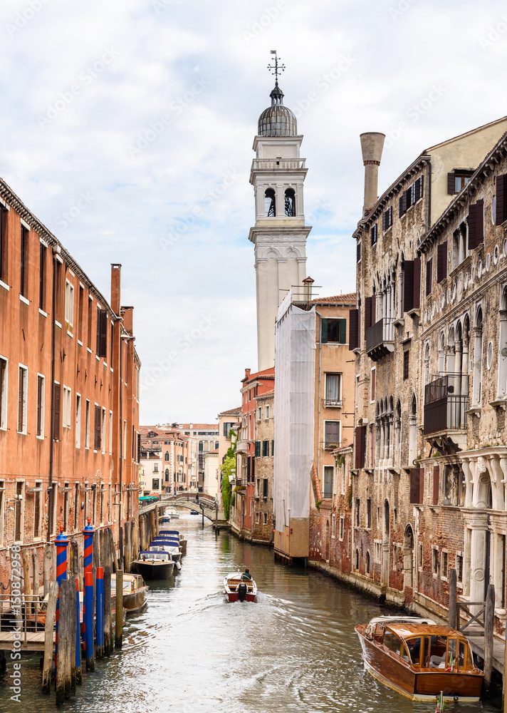 urban view in Venice, italy, boats in the canal, houses and bell tower