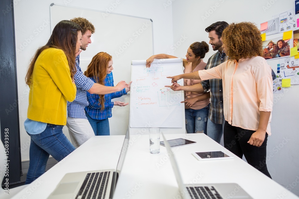 Obraz premium Executives discussing over flip chart board 