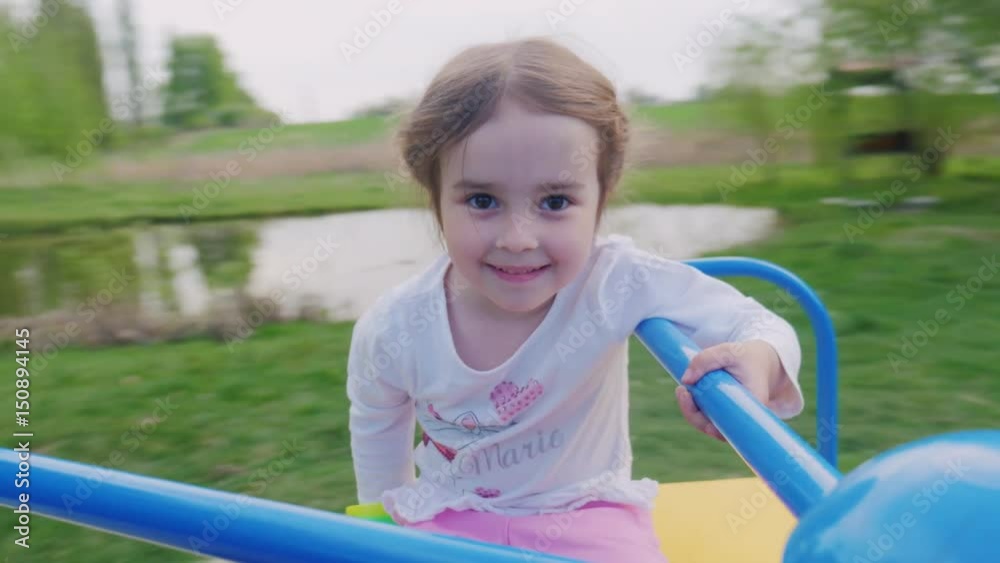 Little girl is riding on a swing. The background behind it moves fast. POV video Little girl is riding on a swing. The background behind it moves fast. POV video