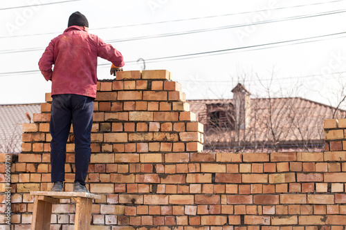 Worker builds a brick wall in the house © schankz