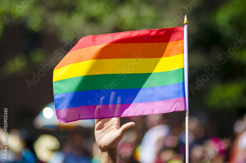 Rainbow flag flying at a summer gay pride parade on the streets of downtown New York City