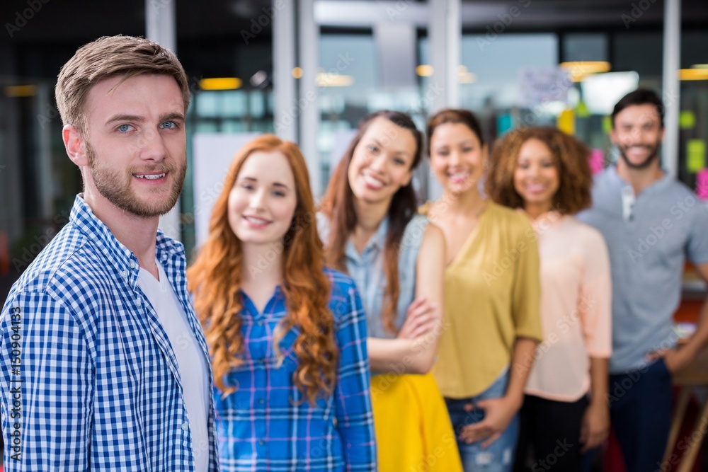 Obraz premium Portrait of male executive standing in front of colleagues