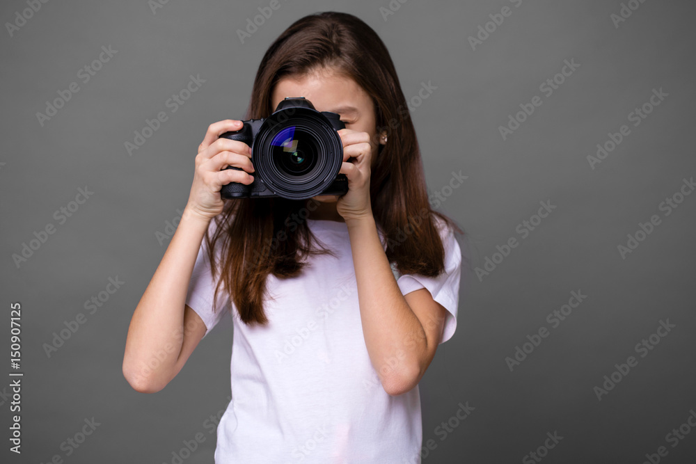 Cute brunette little girl holding an photo camera Cute brunette little girl holding an photo camera