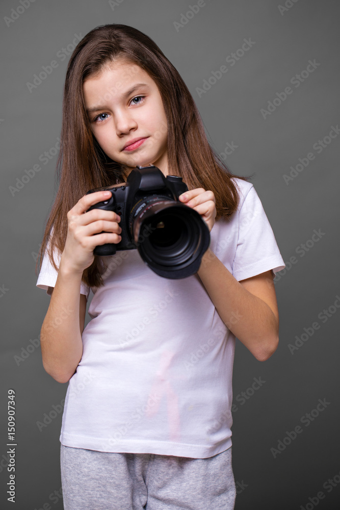 Cute brunette little girl holding an photo camera Cute brunette little girl holding an photo camera