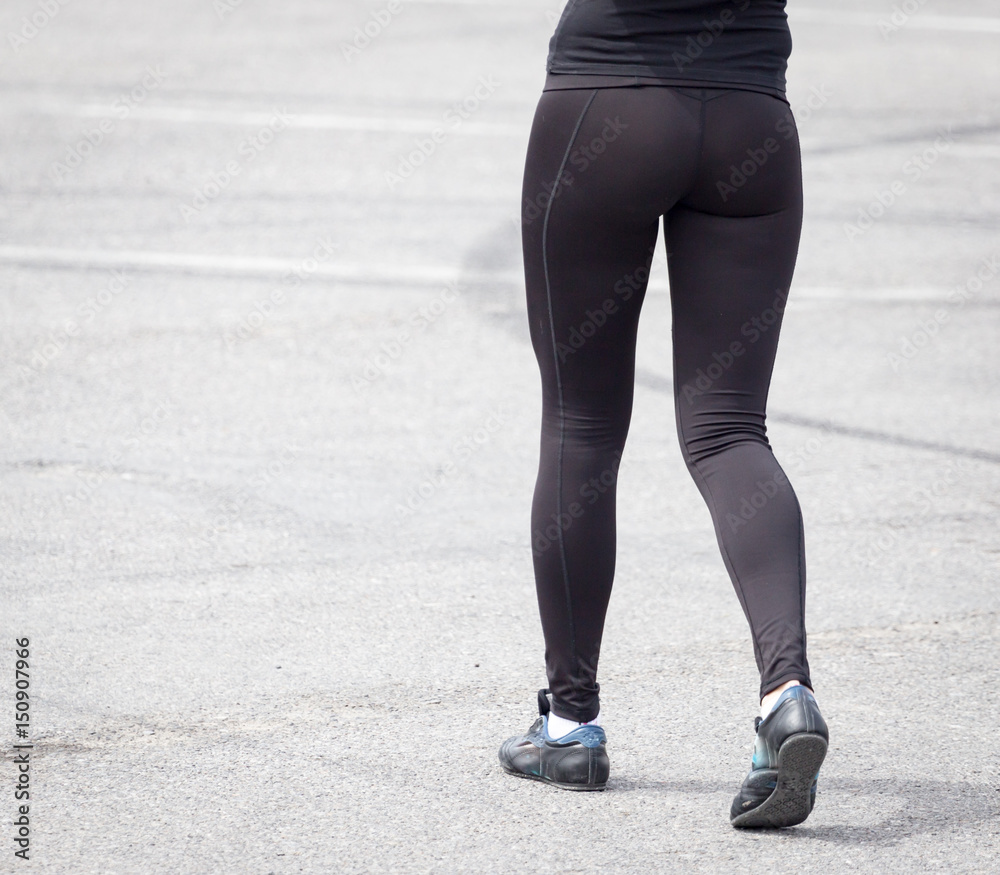 Legs of a girl in black pantyhose walking along the road Legs of a girl in black pantyhose walking along the road