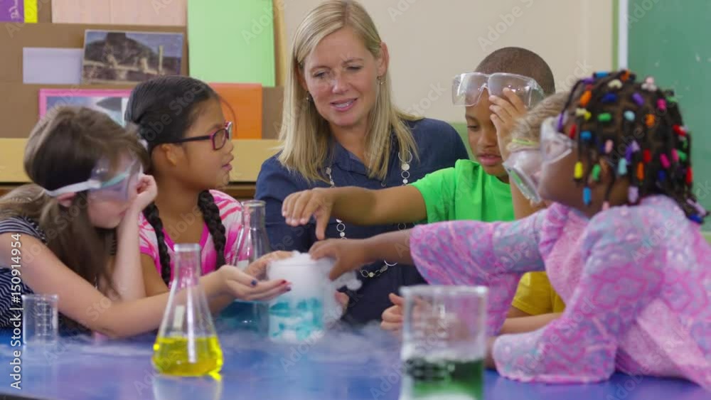 Teacher and group of students make a science experiment in school classroom Teacher and group of students make a science experiment in school classroom