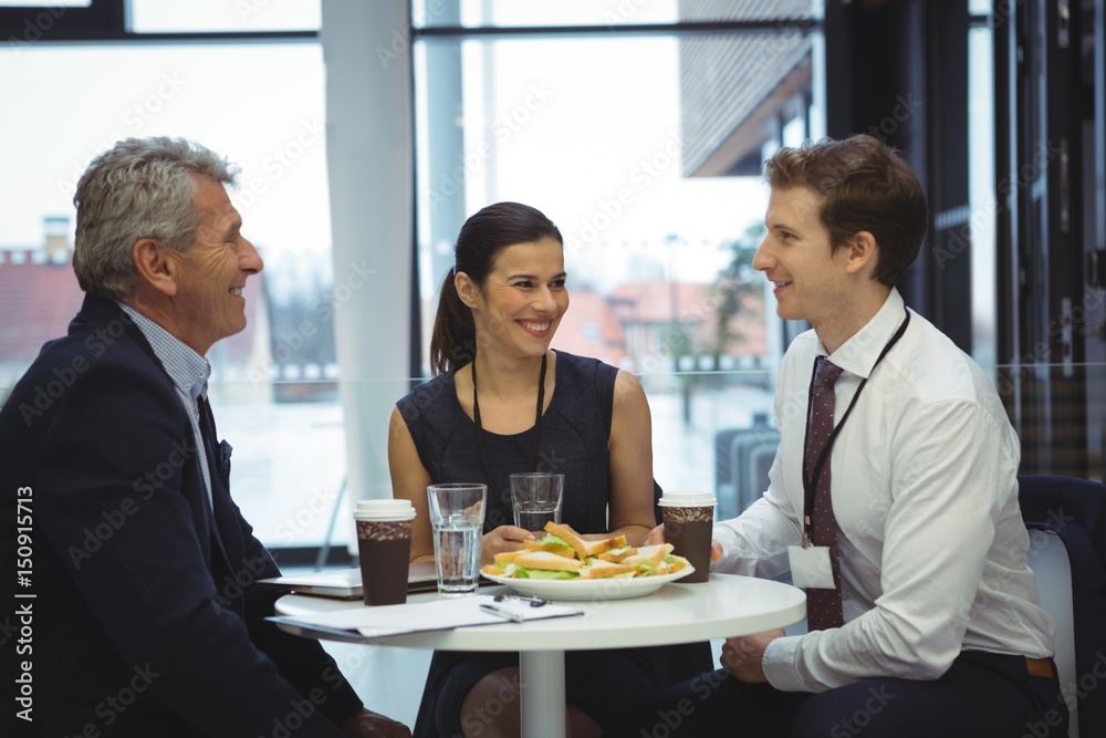 Businesspeople interacting while having breakfast Businesspeople interacting while having breakfast