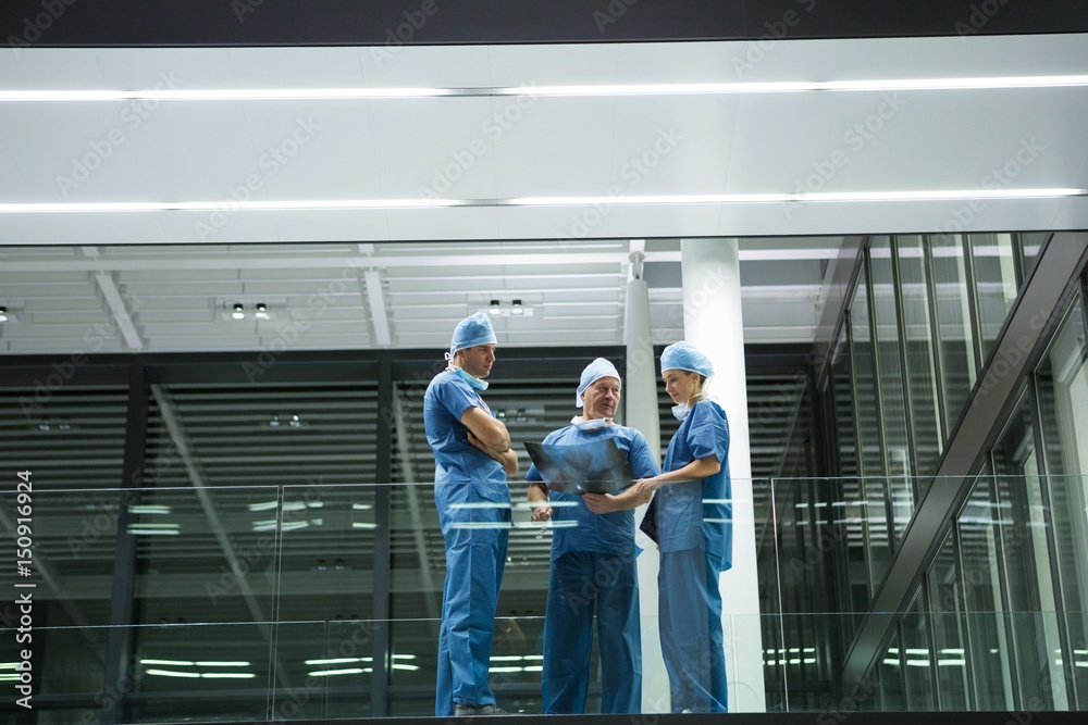 Team of surgeons discussing x-ray in corridor Team of surgeons discussing x-ray in corridor