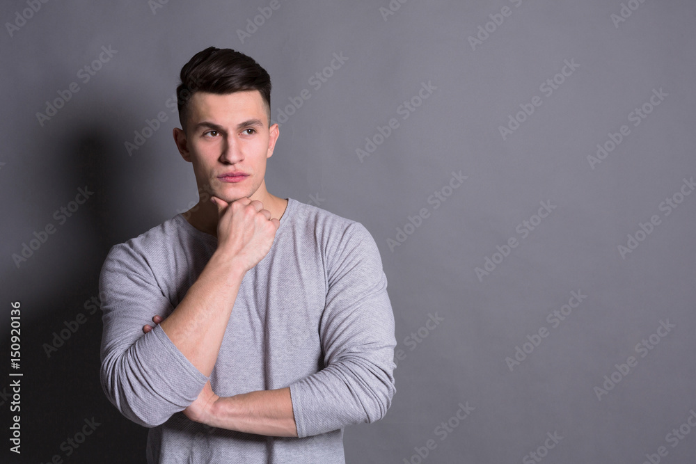 Pensive young man portrait at studio background.