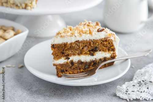 slice of carrot cake with cream cheese frosting and nuts