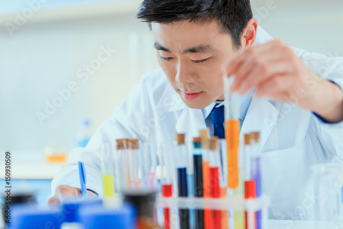 young asian doctor in uniform working at testing laboratory, chemical laboratory