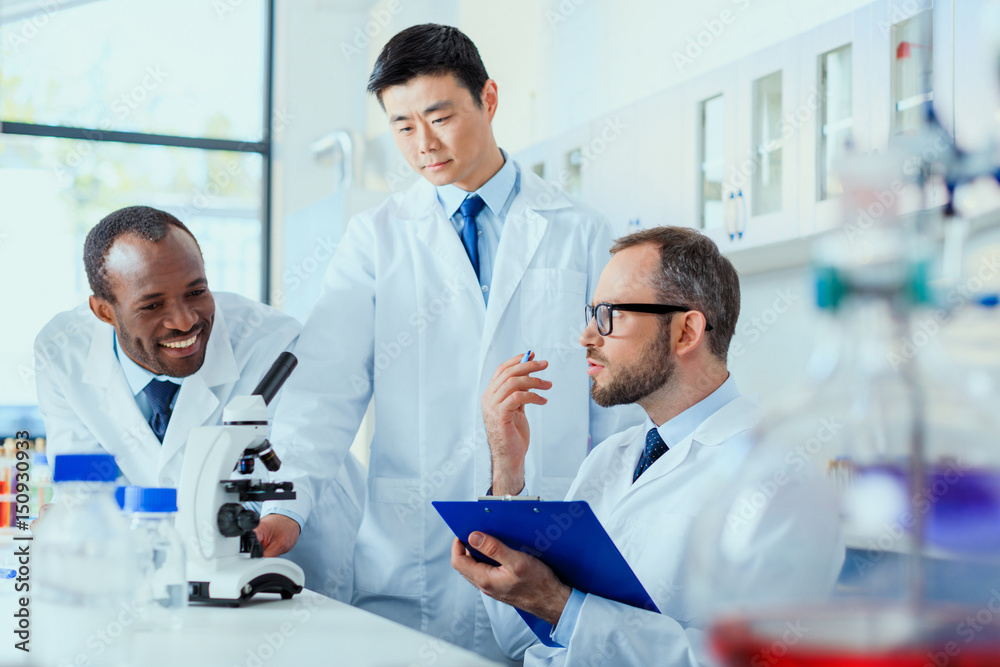 Fototapeta premium young doctors in uniform working at testing laboratory, laboratory technicians