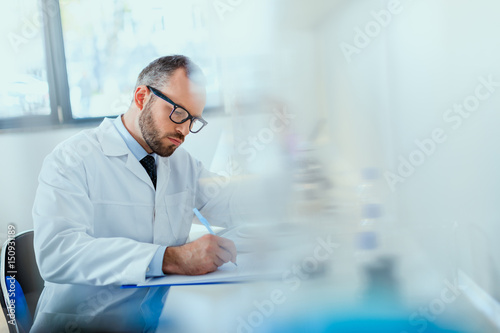 young doctor in uniform working at testing laboratory at clinic  doctor concept