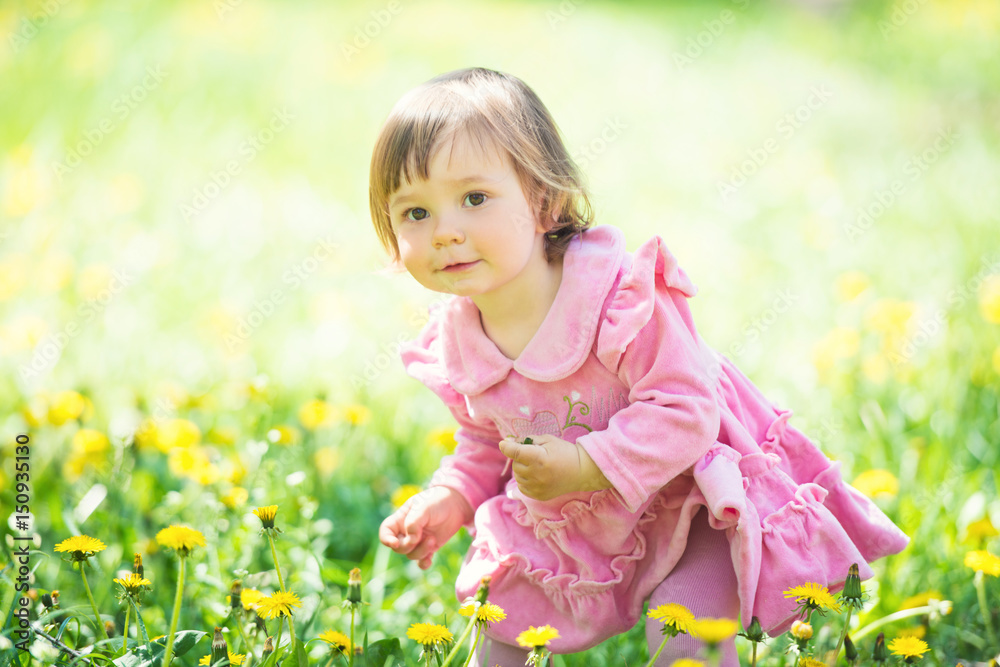 Girl in pink dress with dandelion on green grass. Girl in pink dress with dandelion on green grass.
