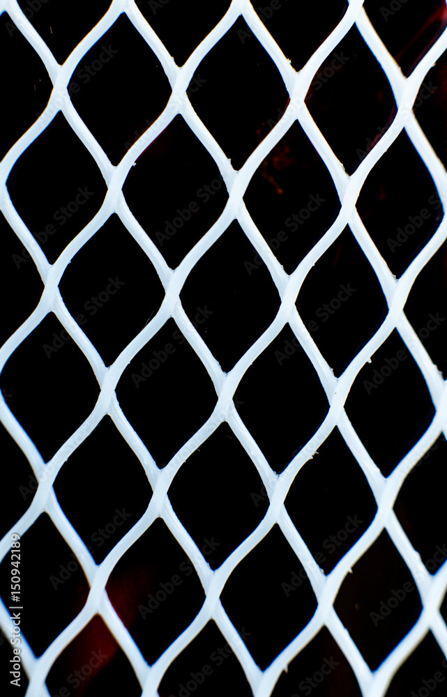 Fototapeta premium White plastic mesh agains black backdrop