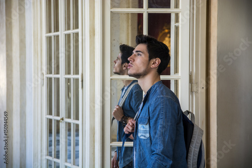 Half Body Shot of a Thoughtful Handsome Young Man, Looking Away Inside a Museum