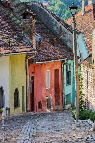 Ancient alley with colourful buildings in Sighisoara, Romania.
