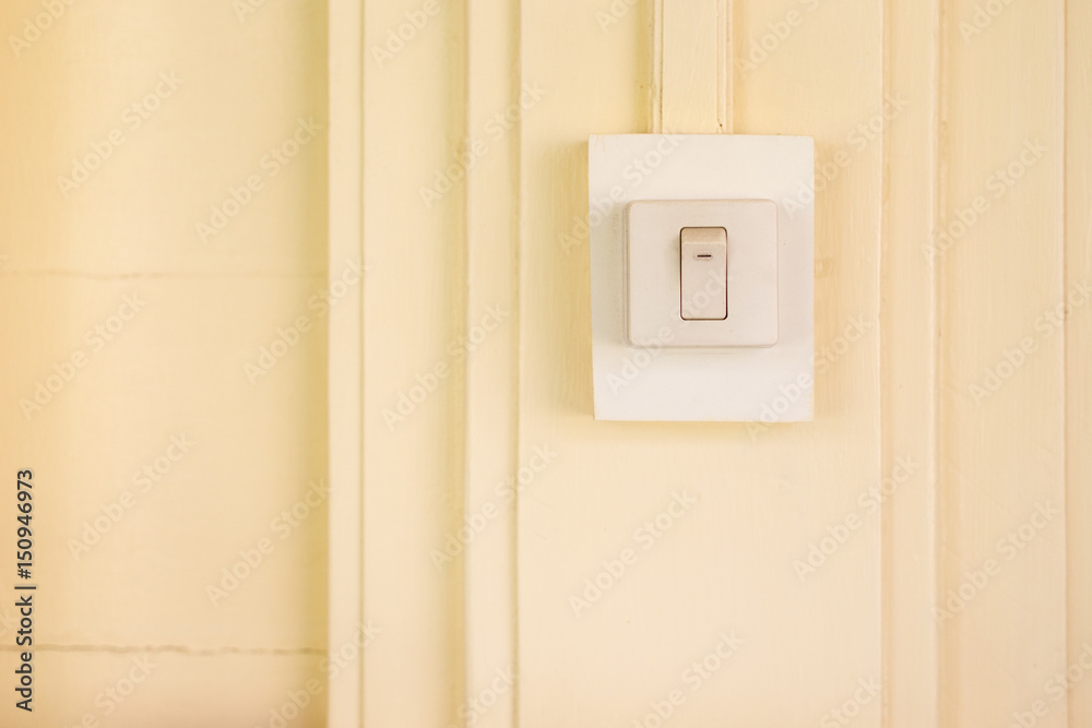 Old electric switch on the yellow wooden wall close up. Old electric switch on the yellow wooden wall close up.