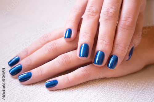 Female hands with bright blue manicure 
