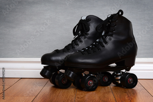 men's quad roller skates on wood floor photo