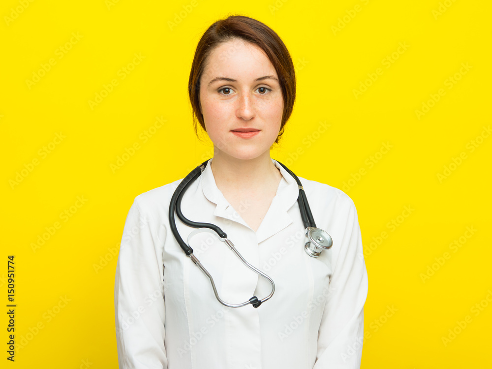 Young female doctor with a stethoscope on yellow background Young female doctor with a stethoscope on yellow background