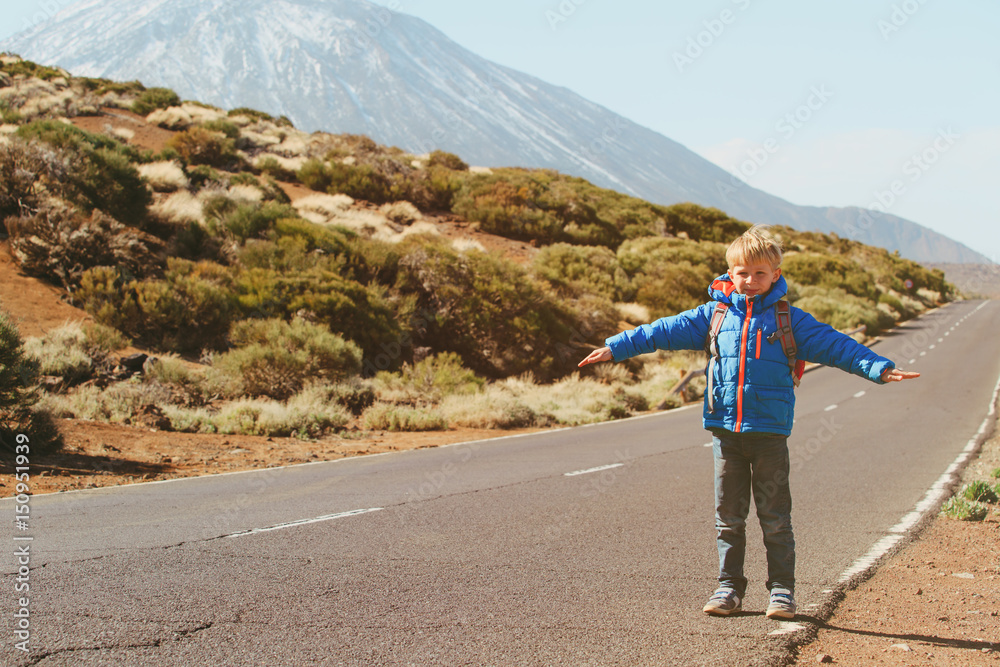 little boy travel on the road in mountains