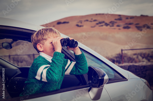 little boy travel by car in mountains