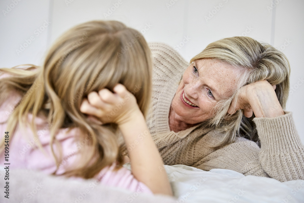 Senior woman relaxing with her granddaughter on the bed Senior woman relaxing with her granddaughter on the bed