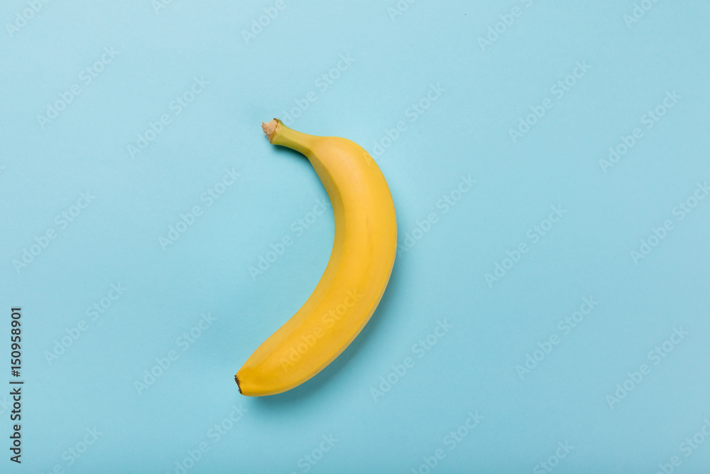Top view of fresh yellow banana isolated on blue, colorful background