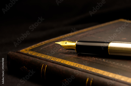 万年筆と古びた本 / Still life image of a fountain pen and an old book. photo