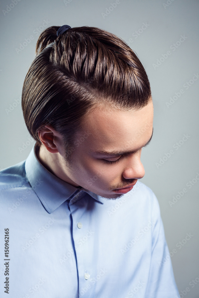 Side top view portrait of young man with top knot hairstyle. studio shot. Side top view portrait of young man with top knot hairstyle. studio shot.
