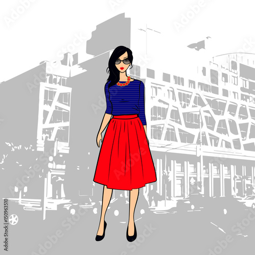 Fashionable cute brunette girl in a striped top and red midi skirt in the city