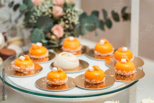 glass stand with pastry on a wedding candy bar table