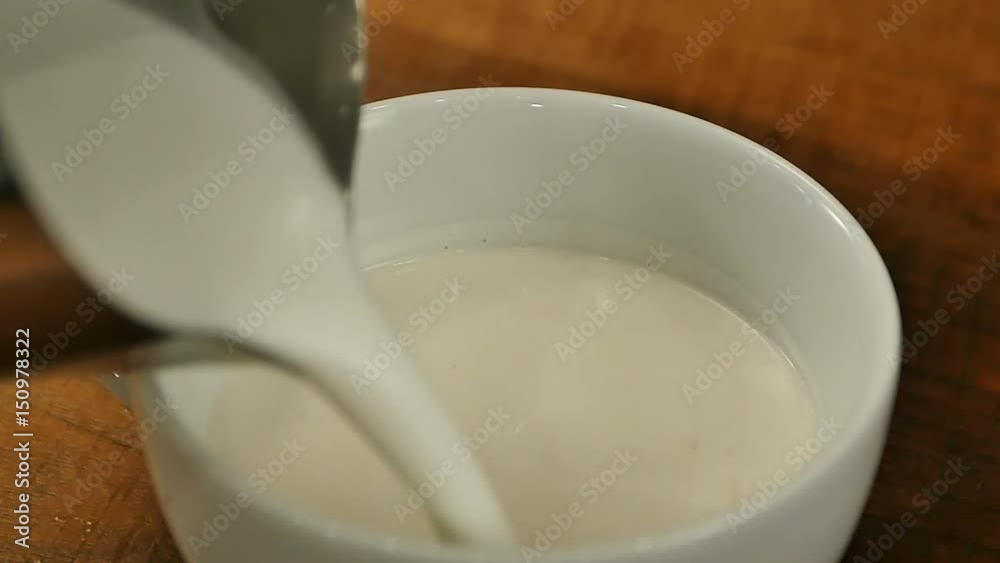 Pouring milk into a cup of coffee Pouring milk into a cup of coffee