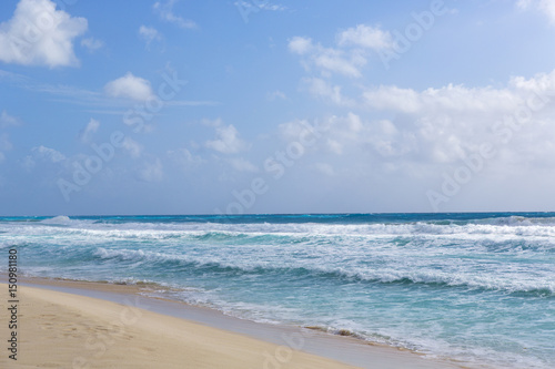 Fototapeta Naklejka Na Ścianę i Meble -  Beautiful beach view on the shores of the Caribbean sea. Blue sky with turquoise water and big waves. Surfer's paradise.