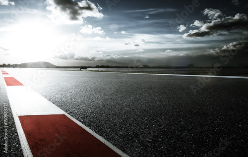 Racetrack with red and white safety sideline ,dramatic cloudy sky and cold mood filter apply . photo