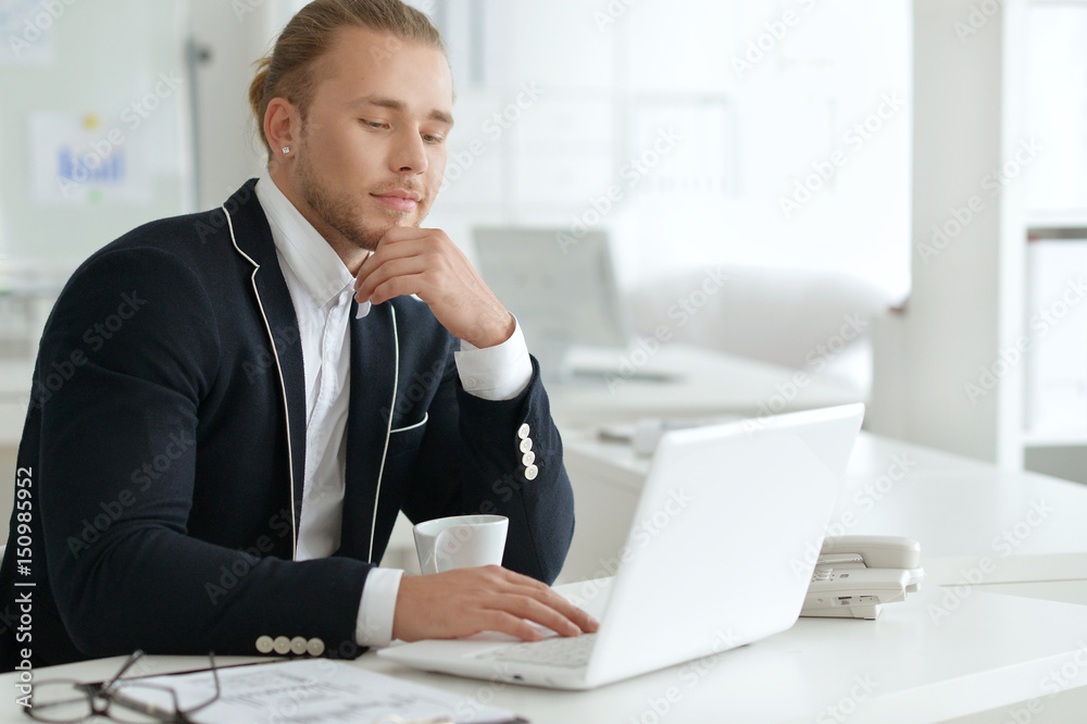 Portrait of a young business man with a laptop