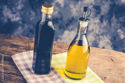 olive oil bottle and balsamic vinegar on rustic table - italian food concept