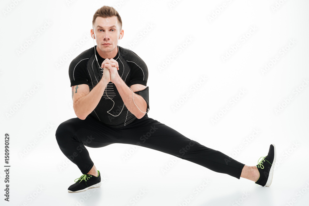 Portrait of a handsome sportsman doing stretching exercises before jogging Portrait of a handsome sportsman doing stretching exercises before jogging