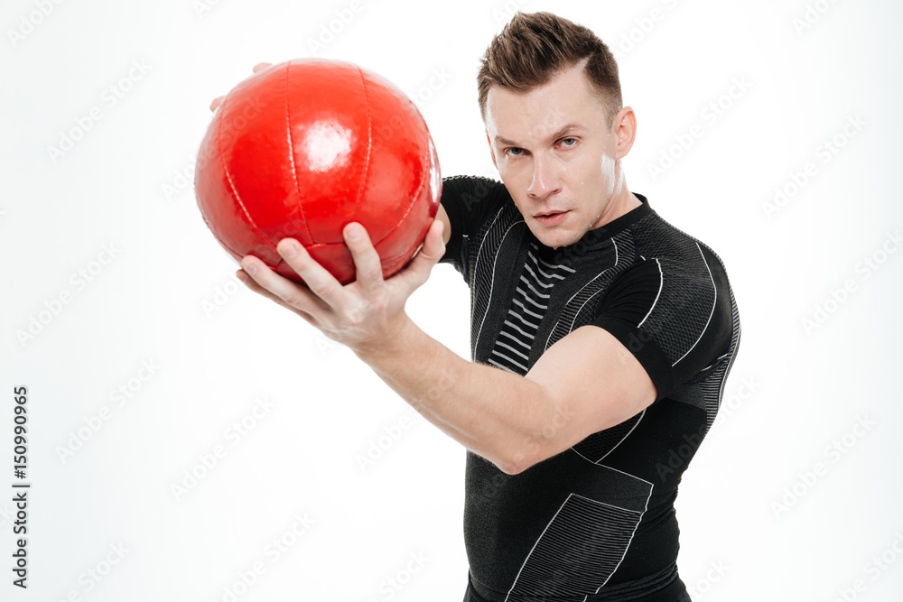 Attractive sportive man doing exercises with heavy fitness ball Attractive sportive man doing exercises with heavy fitness ball