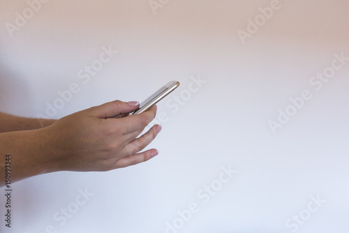 close up view of a woman holding a smart phone over white background. Millennial, Technology concept,
