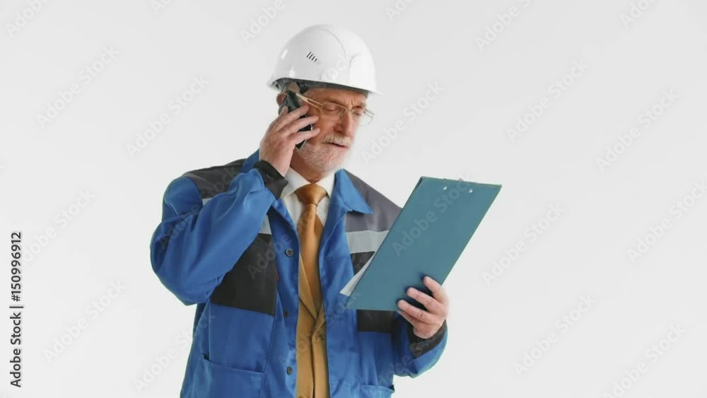 Older the developer previews the report with construction and talking on the phone with the superintendent Older the developer previews the report with construction and talking on the phone with the superintendent