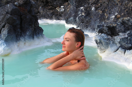 A woman enjoys spa in hot spring Blue Lagoon in Iceland